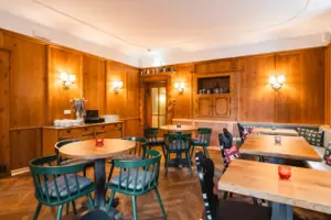 HENRI Gastronomie Kitzbühel Een kamer met tafels en stoelen.