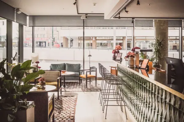 HENRI Düsseldorf Een kamer met een bar en stoelen.