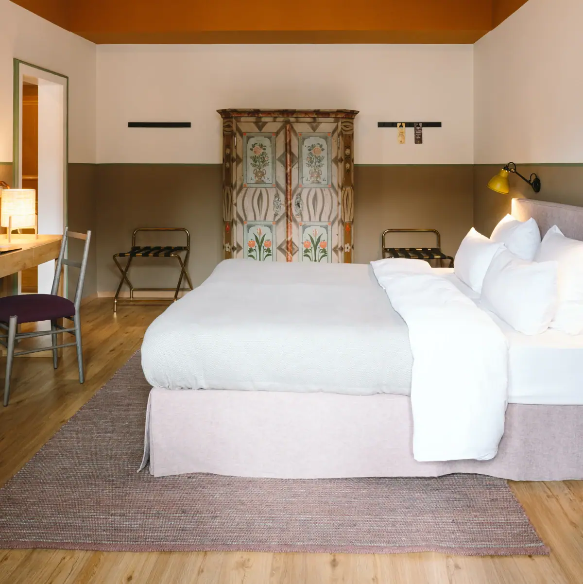 Een mooie hotelkamer in het HENRI Garmisch-Partenkirchen met een bed en een bureau.