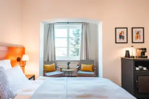 Bed Slaapkamer met bed en stoelen, inclusief nachtkastje en kussens.