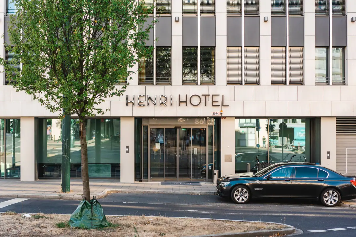 Een auto die voor een hotel geparkeerd staat.