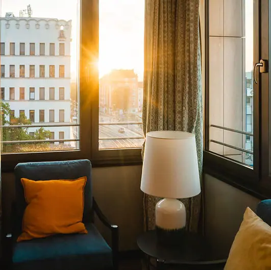 Bekijk Een kamer met een lamp en een stoel.