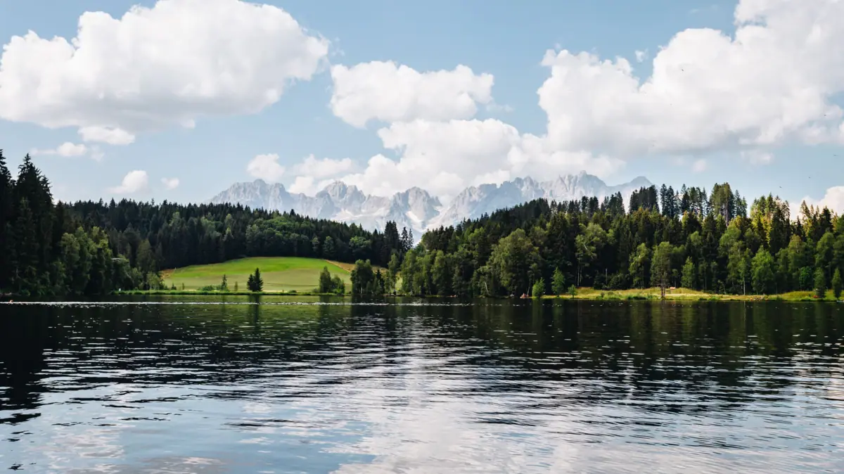 Kitzbühel Schwarzsee Het Zwarte Meer met bomen en bergen op de achtergrond.
