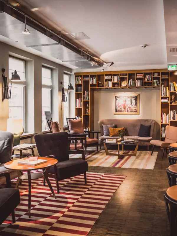 Zitgroepen bestaande uit fauteuils, tafels en een bank in de loungeruimte.