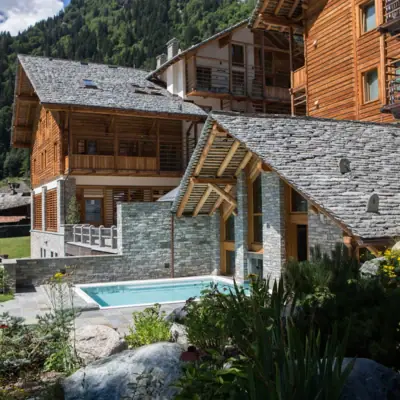 Mira Hotel buitenaanzicht Een hotel met een zwembad op de voorgrond en bergen op de achtergrond.