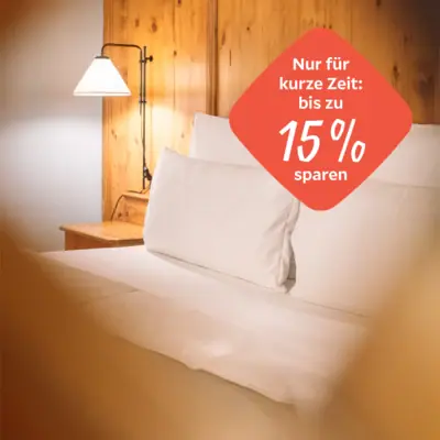 Een bed met witte lakens en een lamp.
