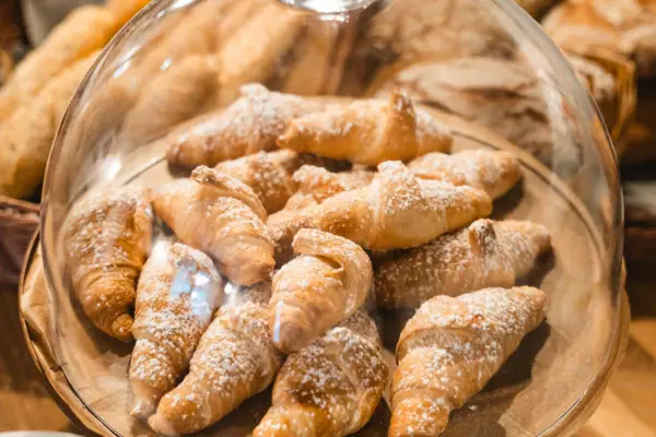 Een bord croissants bestrooid met poedersuiker.