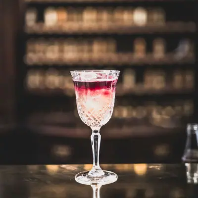 Een glas met een drankje op een bar.