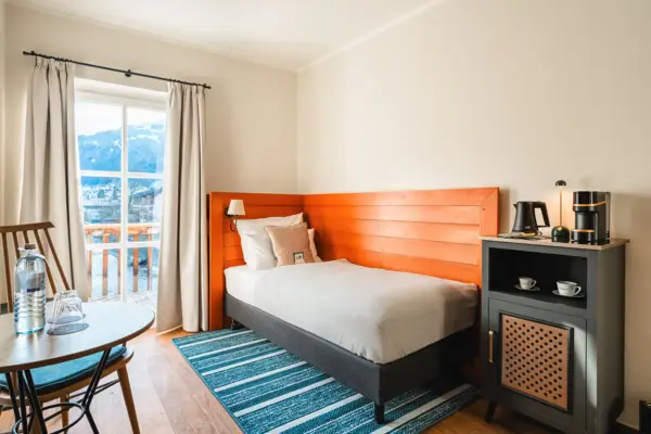 Slaapkamer Een bed in een kamer met nachtkastje en kussens.