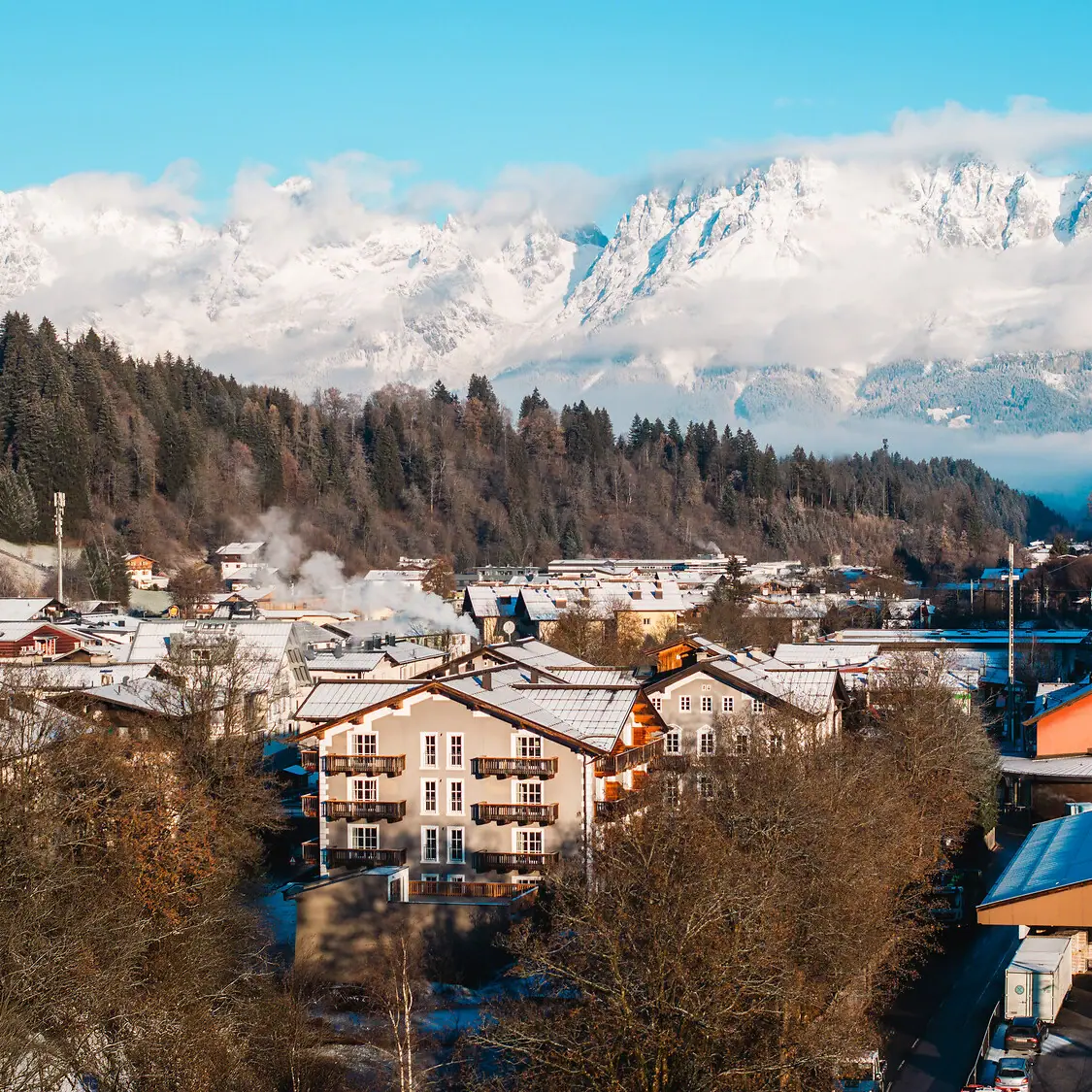 Bergdorp met besneeuwde bergen op de achtergrond.