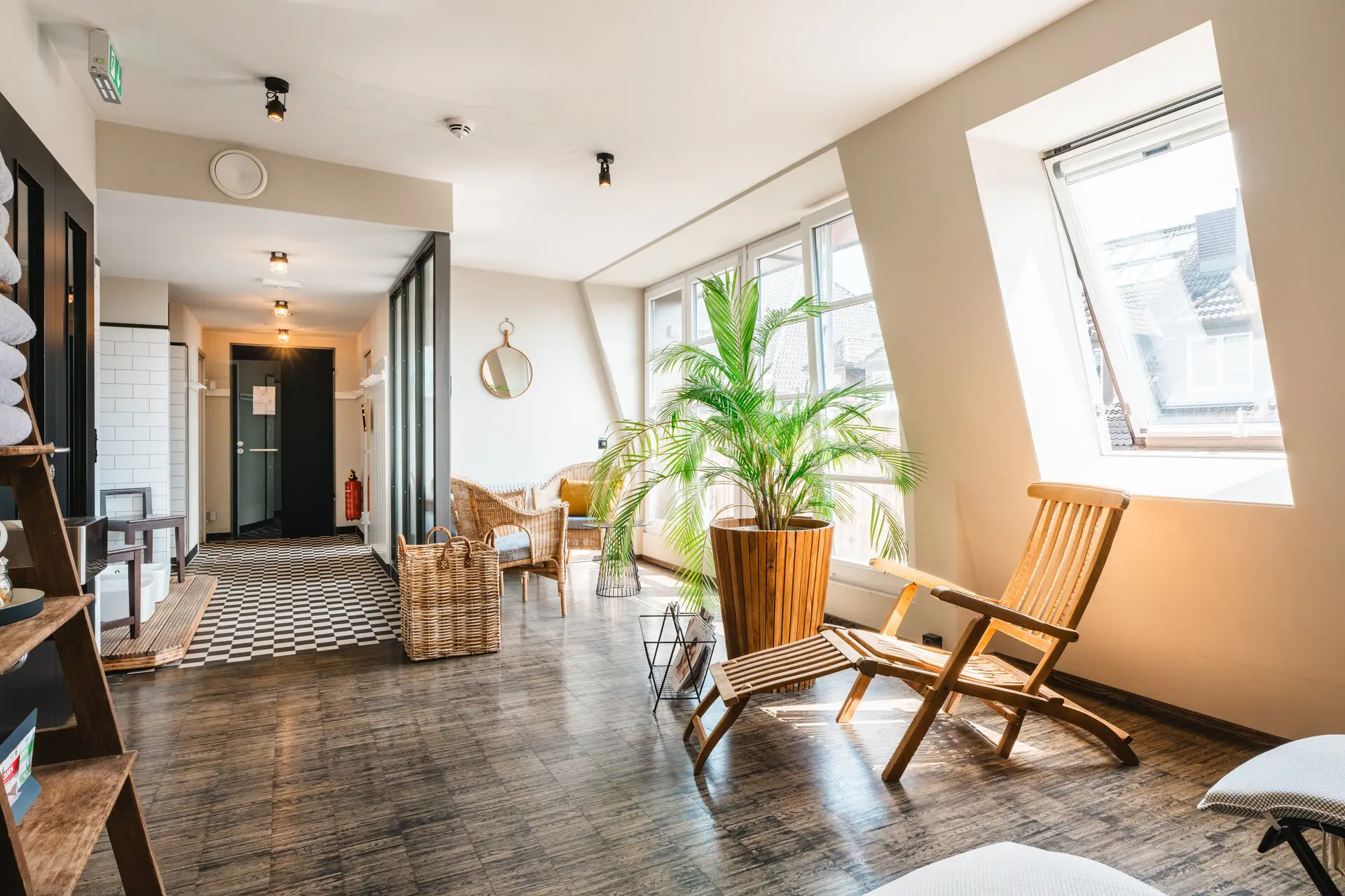 Een kamer met ligstoelen en een plant.