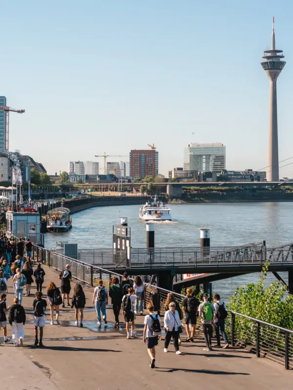 Een groep mensen wandelt over een pad in de buurt van het water.