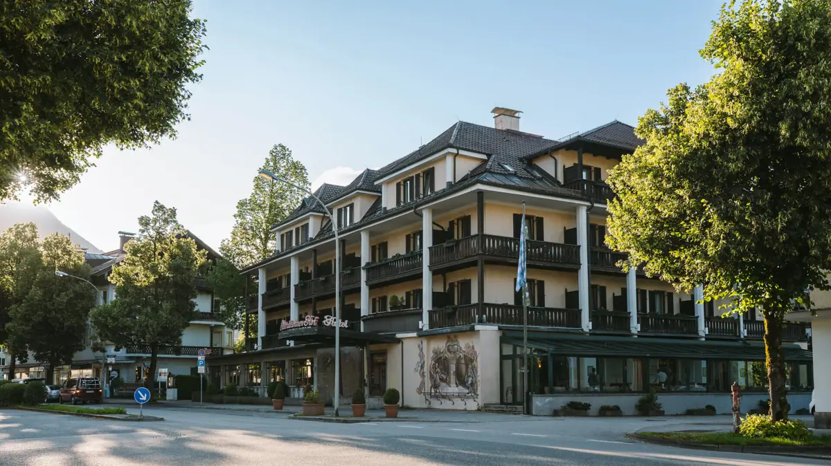 Het buitenaanzicht van het HENRI Hotel Garmisch-Partenkirchen omringd door bomen.