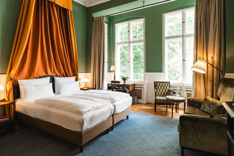 Een kamer met twee bedden en een bank.