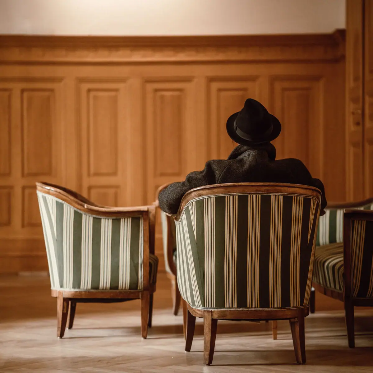 Een man zit op een stoel.