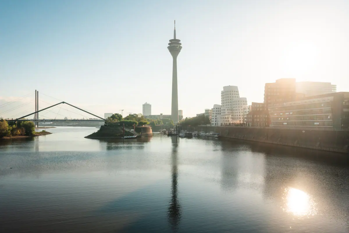 Fietstocht door Düsseldorf Een waterpartij met een grote toren op de achtergrond.