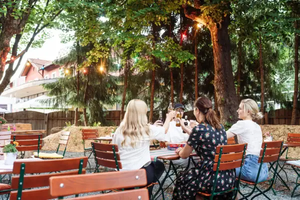 Een groep mensen zit buiten aan tafels.