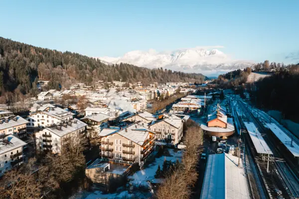 Een besneeuwde stad in de winter met bergen op de achtergrond.