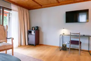 Bureau in HENRI Garmisch-Partenkirchen Een kamer met een televisie en een tafel.