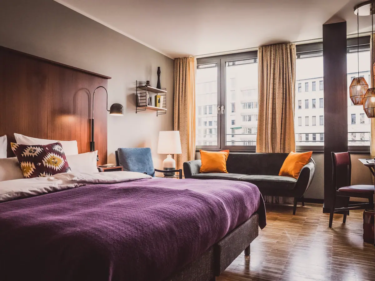 Slaapkamer met paars bed en bank.