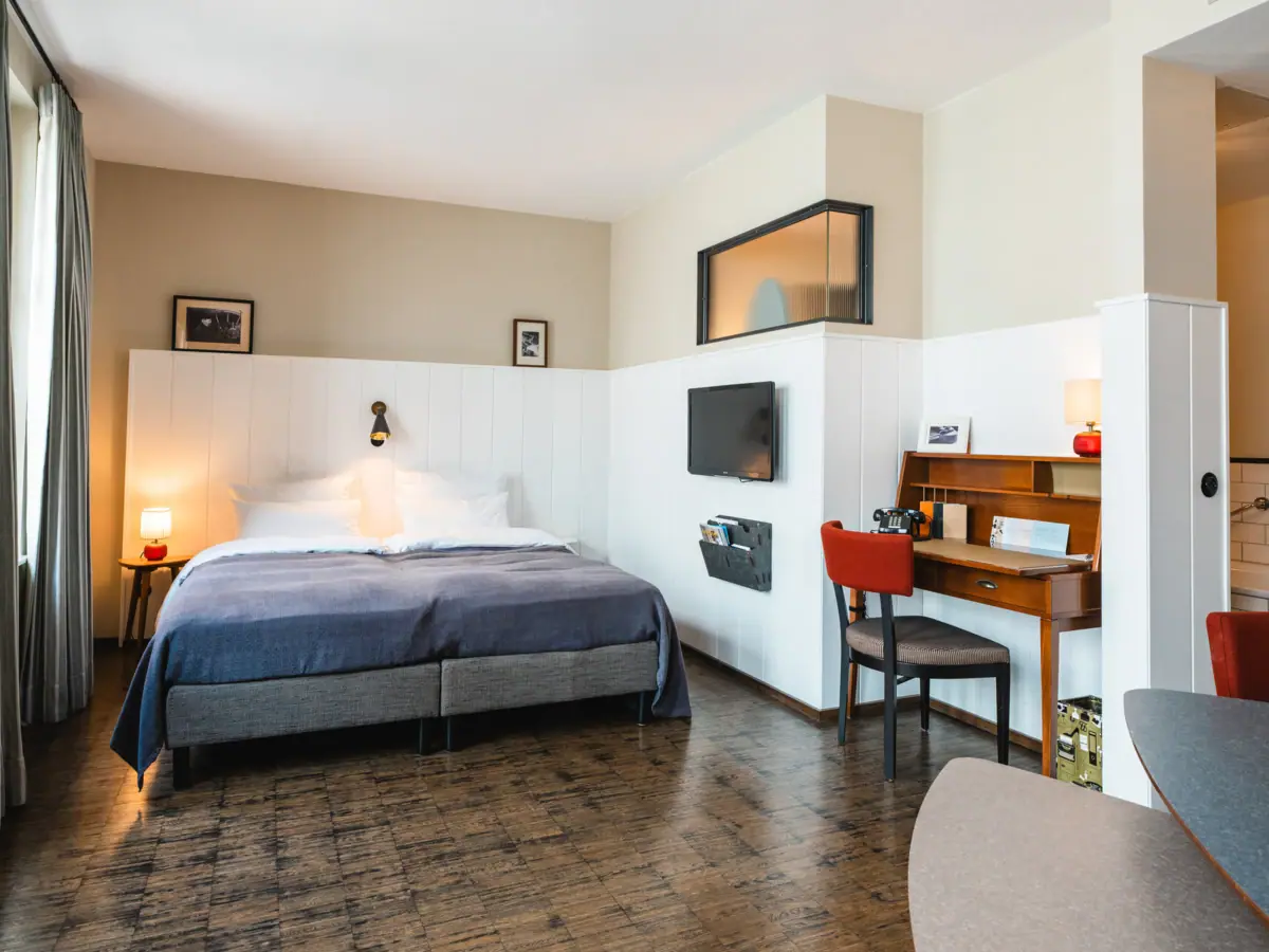 Een kamer met een bed en een bureau.