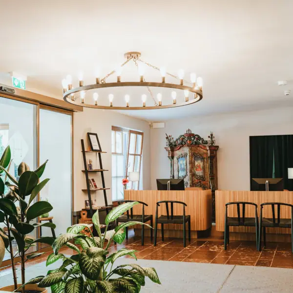 Een kamer met een kroonluchter en stoelen.