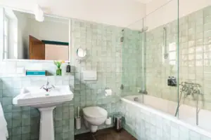 Badkamer met douche met glazen deur en wastafel