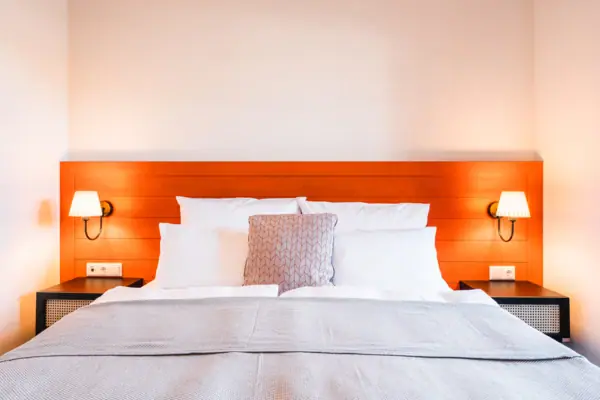 Bed Een bed met kussens en een lamp op het nachtkastje.