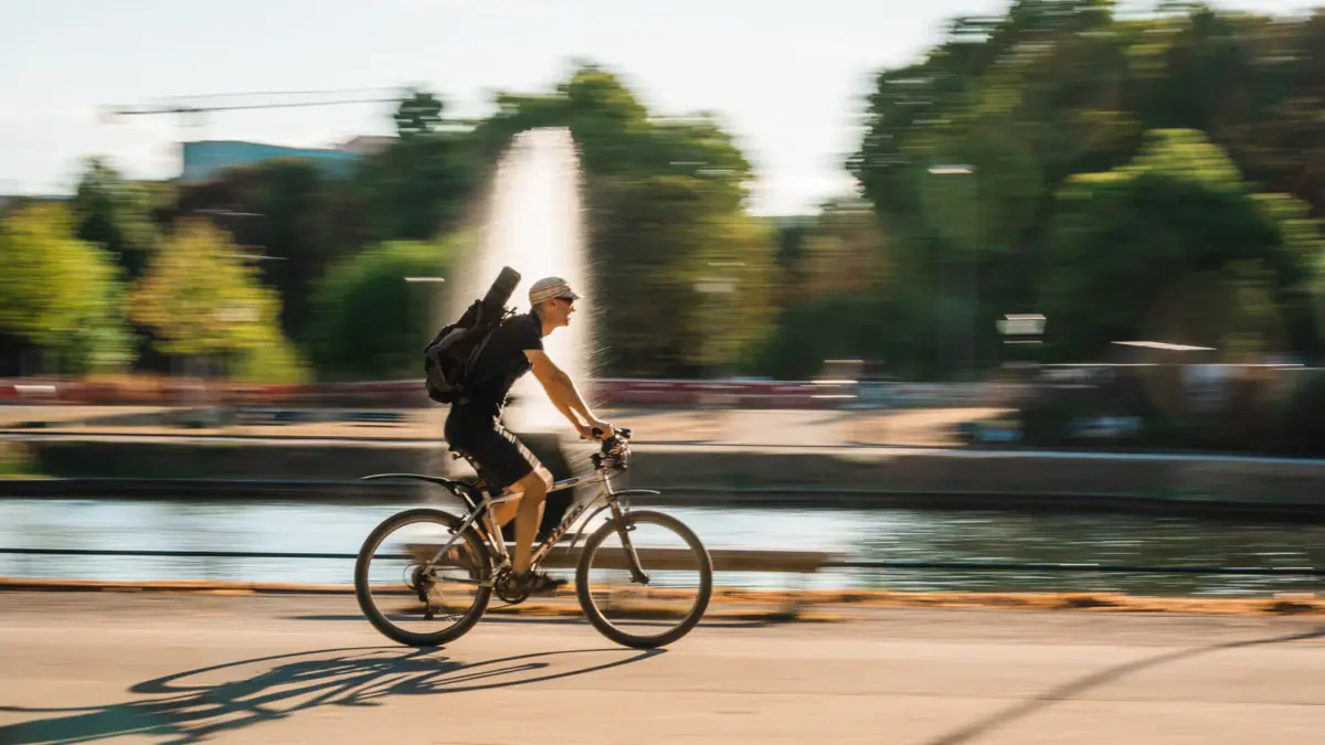 Een man fietst met een rugzak.