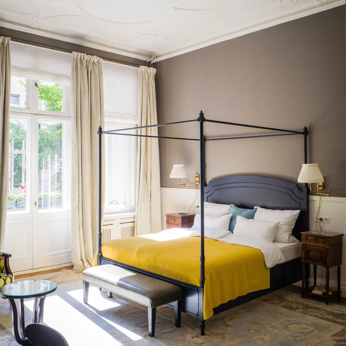 Een Salon-kamer in het HENRI Hotel Berlin met een bed en grote ramen.