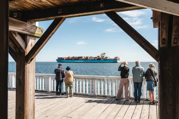 Een groep mensen bekijkt een groot schip vanaf het uitkijkplatform Alte Liebe in Cuxhaven.
